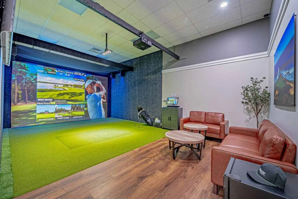 A golfer practicing inside a Rozay Golf simulator bay